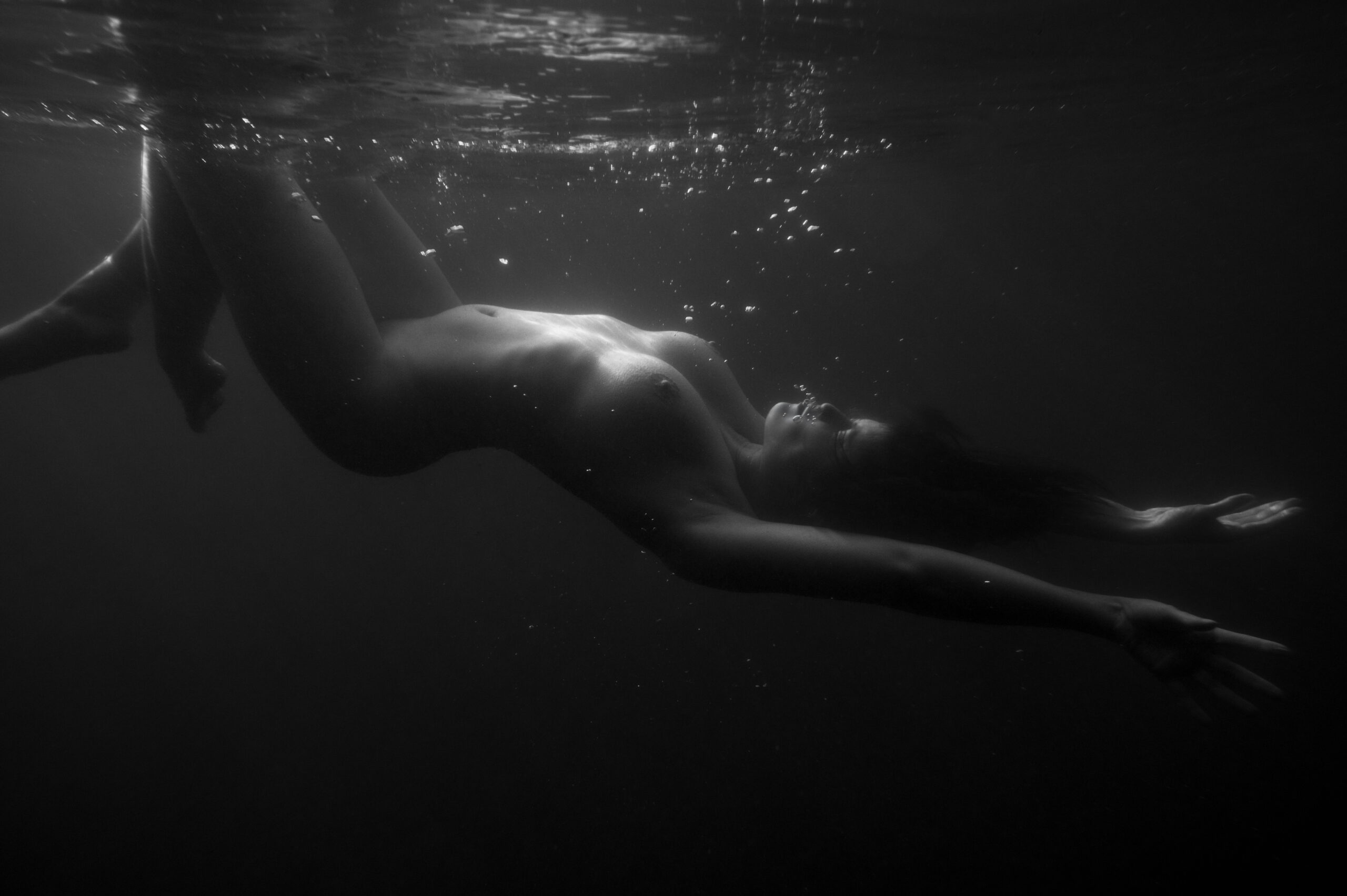 Frau schwebt unter Wasser.